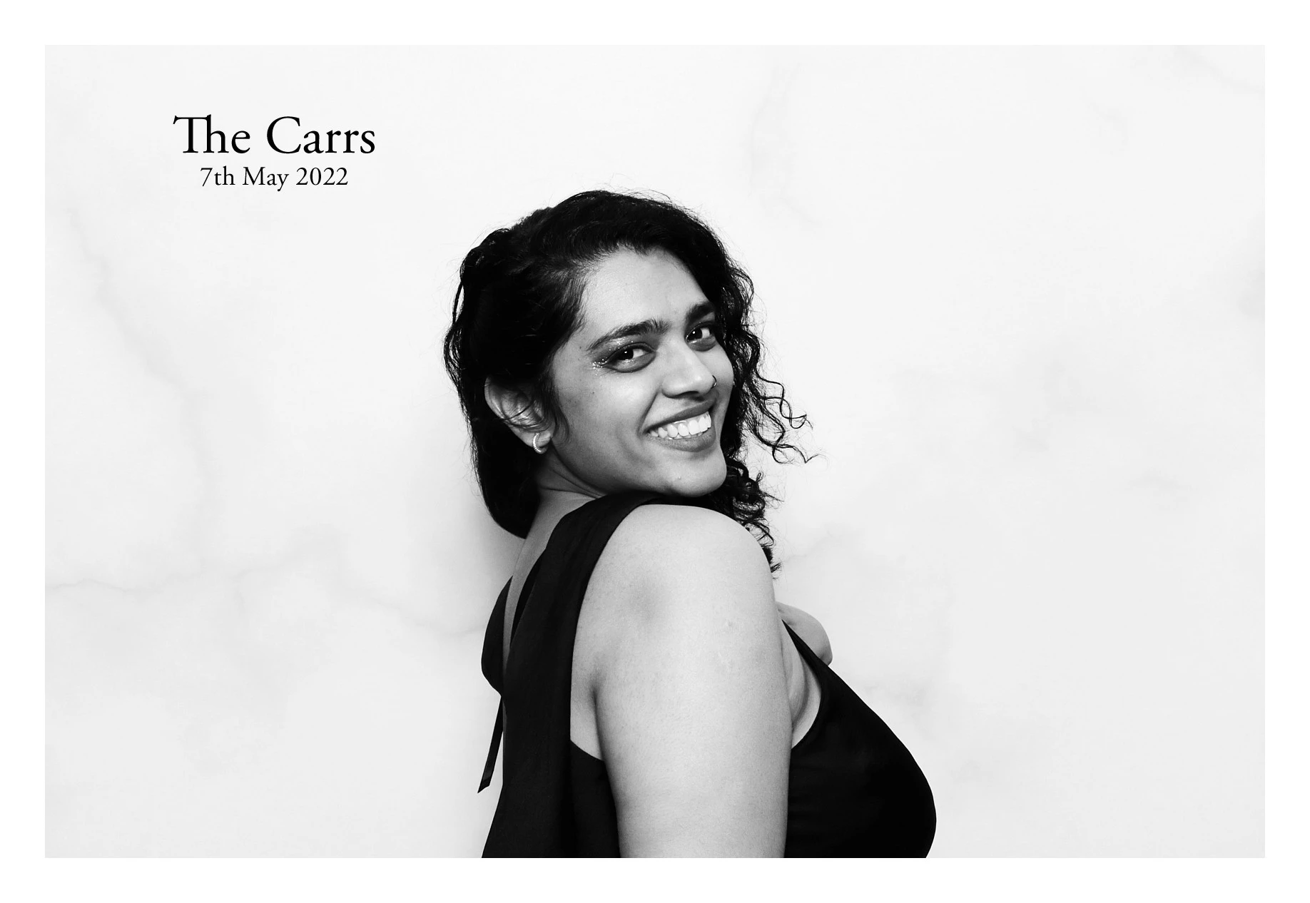 A woman smiling over her shoulder, with text 'The Carrs, 7th May 2022'.