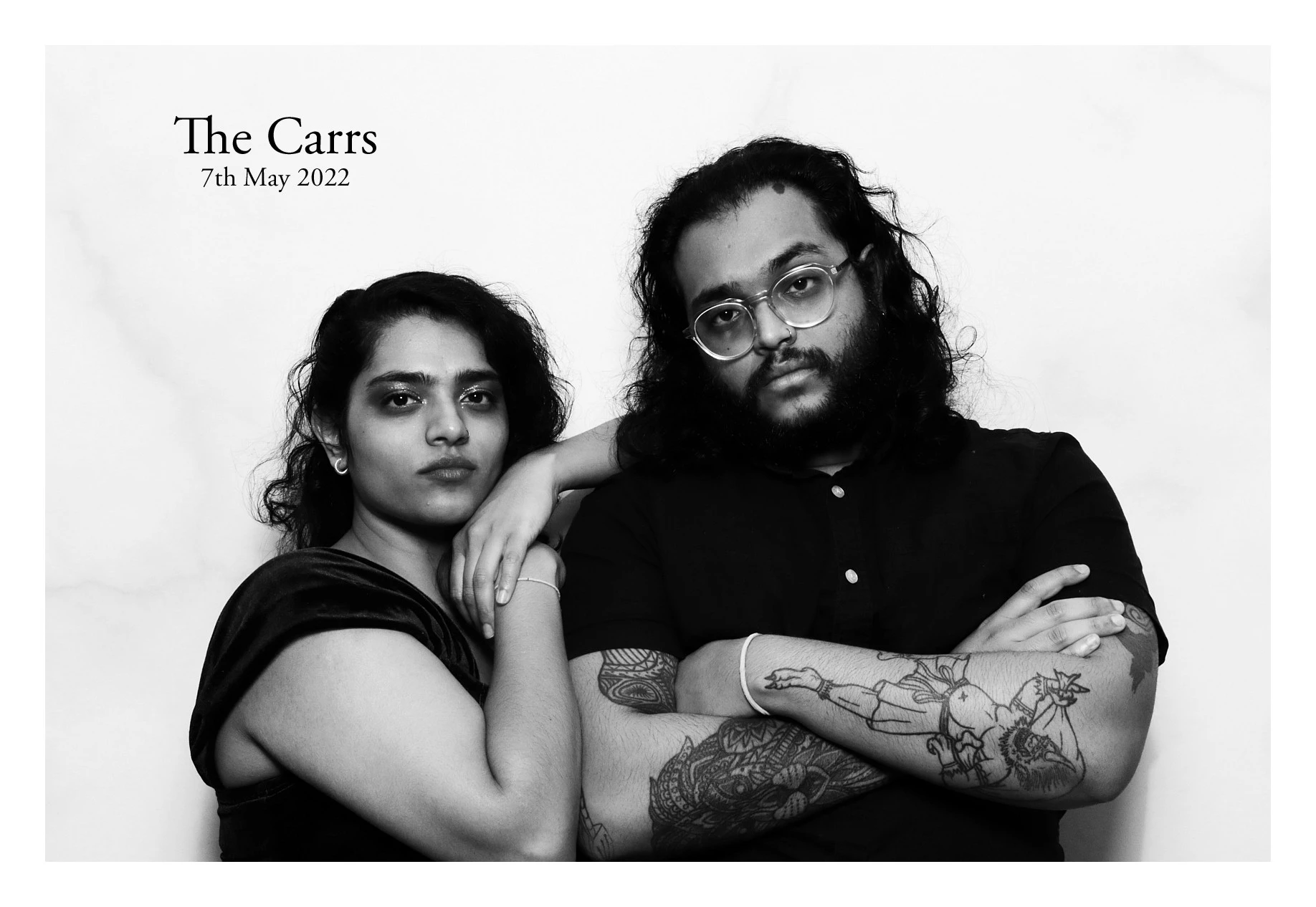 Two guests striking a serious pose in black and white, titled 'The Carrs, 7th May 2022'.